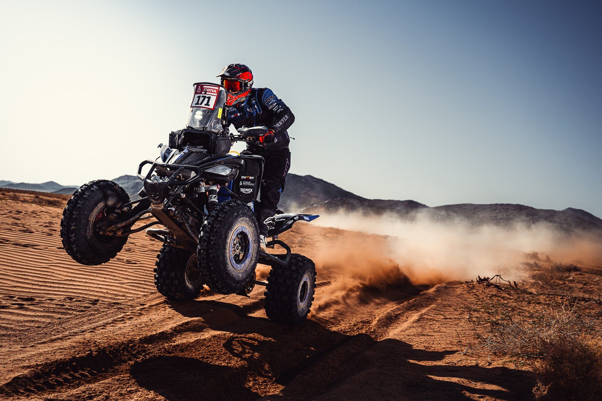 Quad rider in action on desert sand during the Dakar Rally 2024